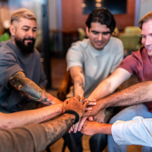 Men stacked hands on a group support therapy Men stacked hands on a group support therapy