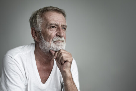 Senior Mann mit grauem Bart mit Blick in die Ferne