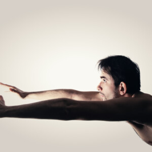 Naked young man on a white background Mann mit nacktem oberkörper schiebt hände weit von sich weg männerdialoge juni 2025