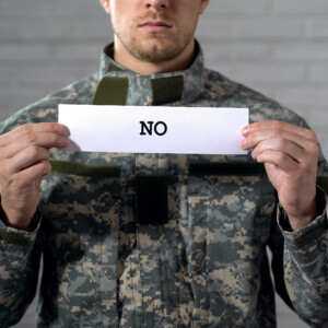 No word written on sign in hands of male soldier, protest against war conflict